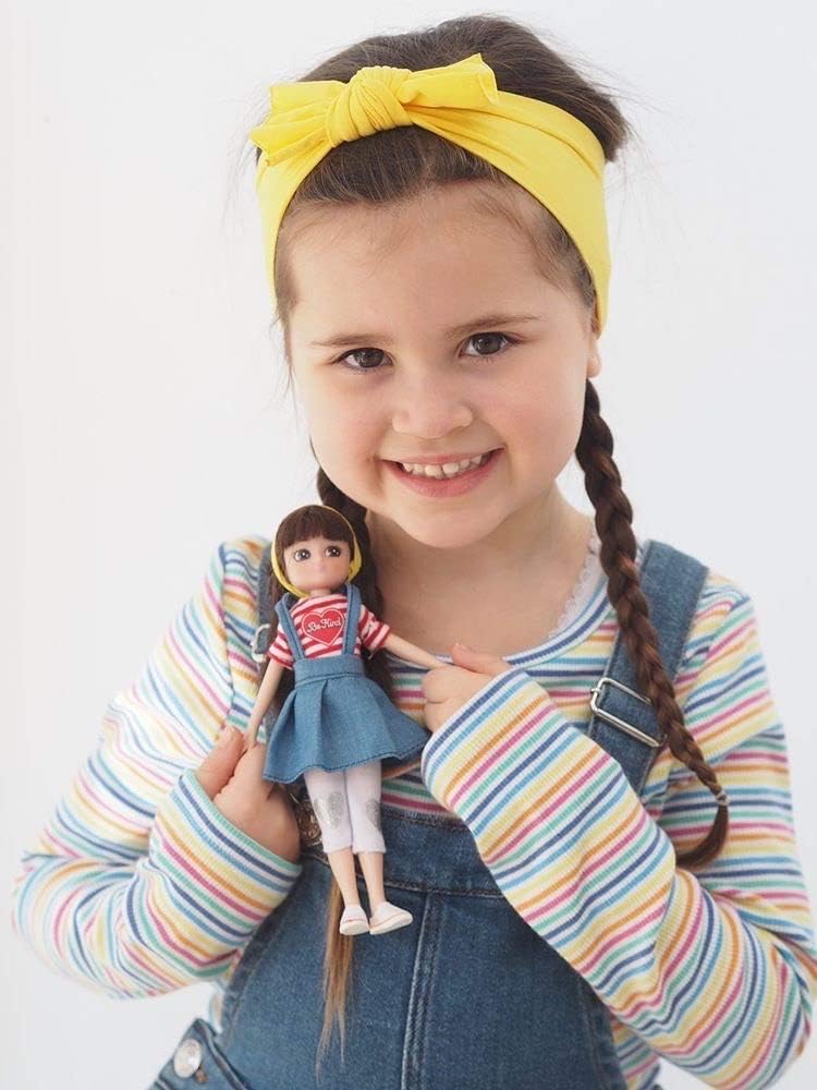 Muñeca Lottie Be Kind con delantal de mezclilla